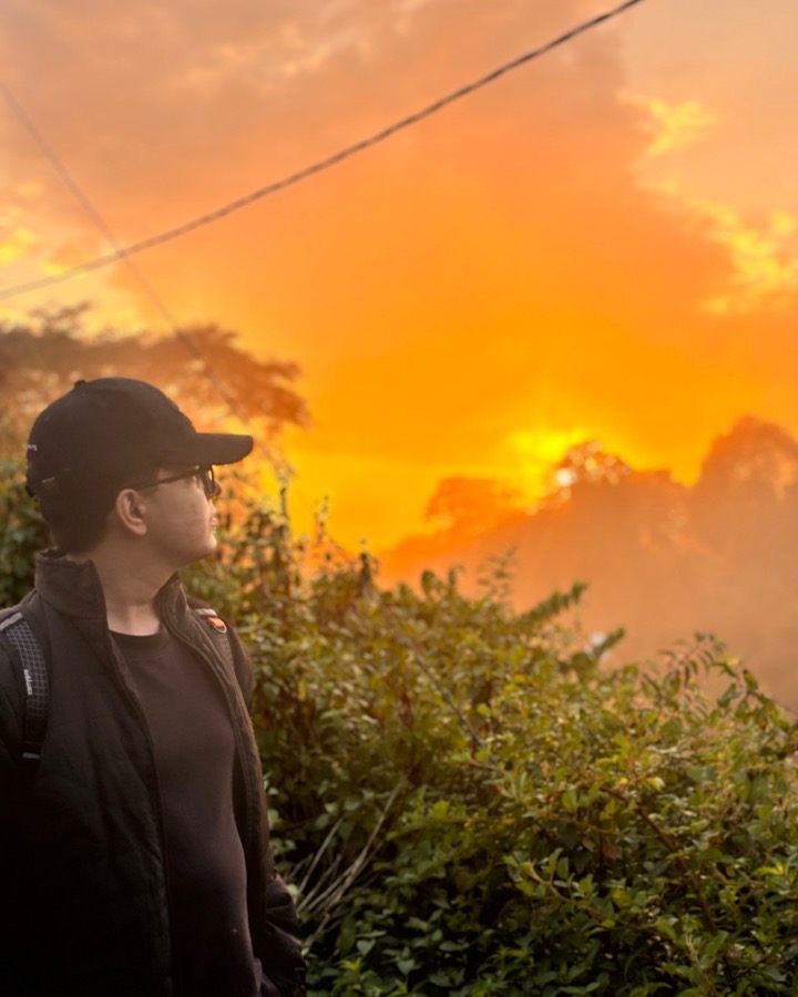 Pratim Narayan Moitra in profile at sunrise, looking out over the hills